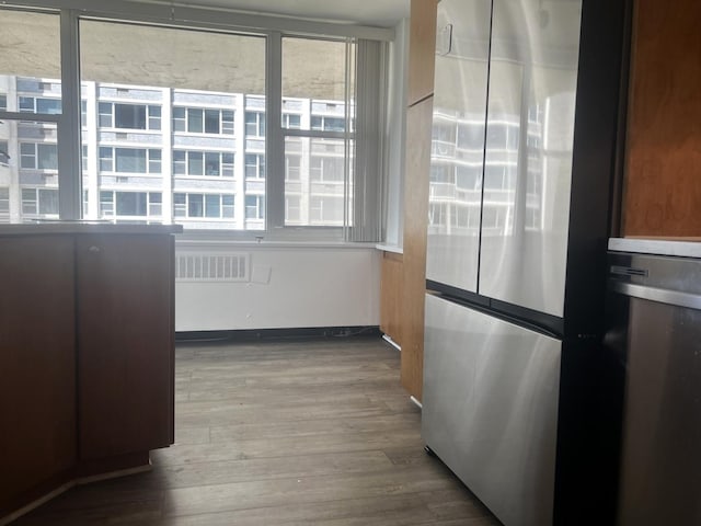 kitchen with visible vents, wood finished floors, and freestanding refrigerator