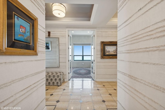 corridor featuring a tray ceiling, light tile patterned flooring, and baseboards