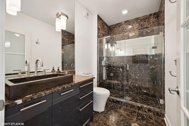 full bathroom featuring a stall shower, marble finish floor, vanity, and toilet