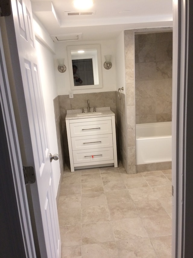 bathroom with vanity with extensive cabinet space, shower / washtub combination, and tile floors