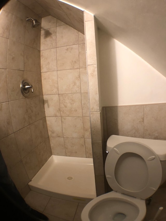 bathroom featuring tiled shower and toilet