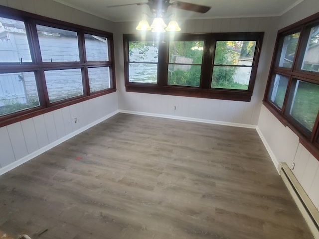 unfurnished sunroom featuring a baseboard radiator and ceiling fan