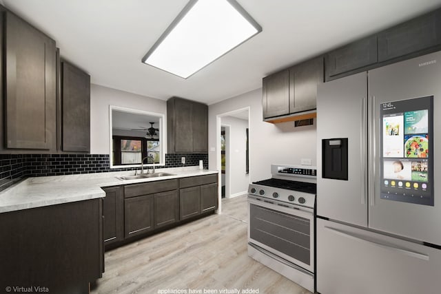 kitchen featuring stainless steel fridge with ice dispenser, sink, dark brown cabinetry, and range