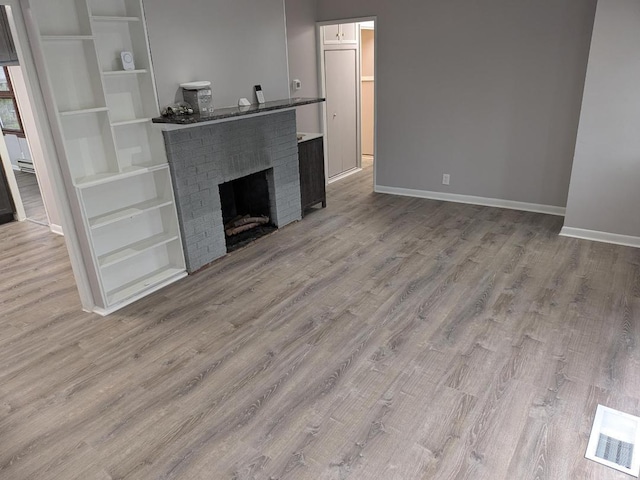 unfurnished living room featuring a fireplace and wood-type flooring