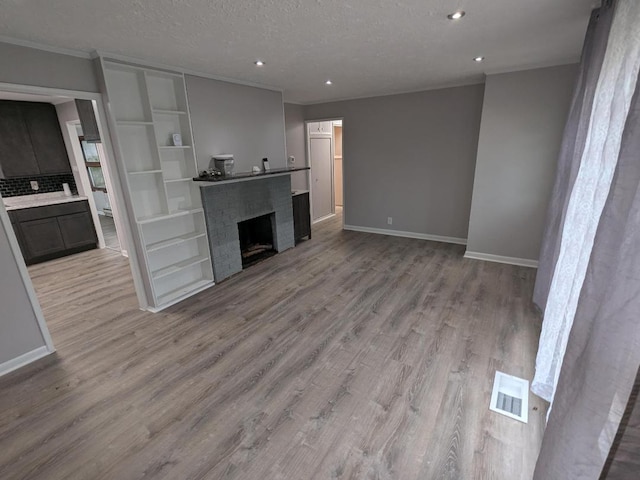 308 Minocqua St, Park Forest, IL 60466 - unfurnished living room featuring light wood-style floors, baseboards, recessed lighting, crown molding, and a textured ceiling