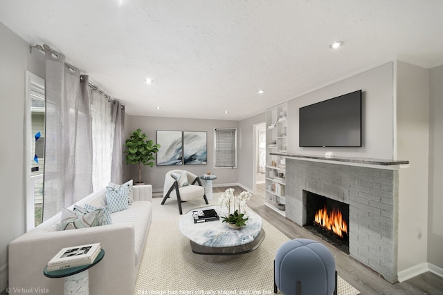 living room with light hardwood / wood-style flooring and a brick fireplace