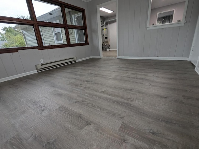 spare room with wood-type flooring and a baseboard heating unit