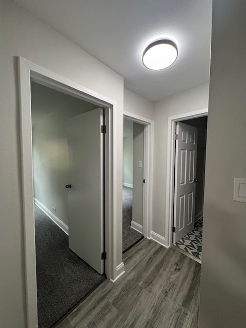 corridor with dark hardwood / wood-style flooring