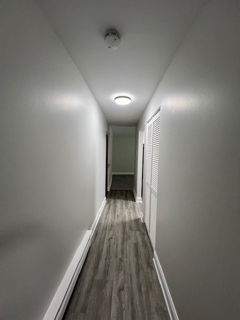 hallway with hardwood / wood-style flooring