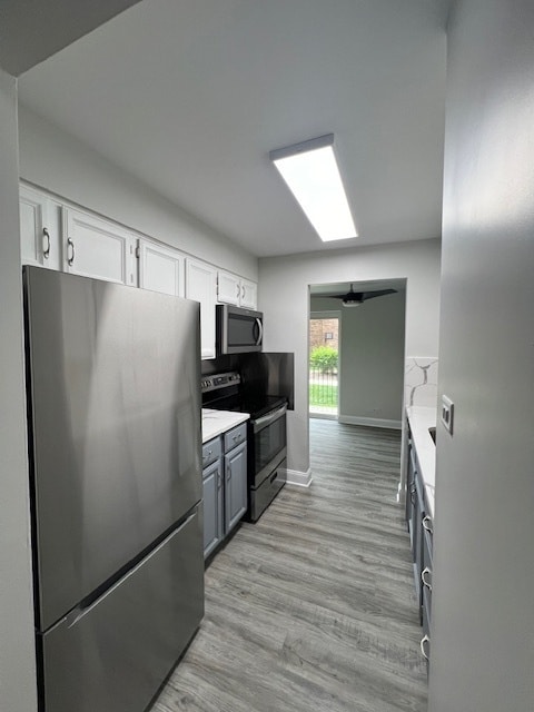 kitchen with ceiling fan, light hardwood / wood-style floors, stainless steel appliances, gray cabinetry, and white cabinetry