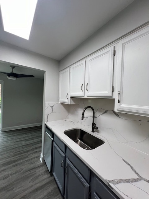 kitchen with white cabinetry, stainless steel dishwasher, dark hardwood / wood-style floors, backsplash, and sink