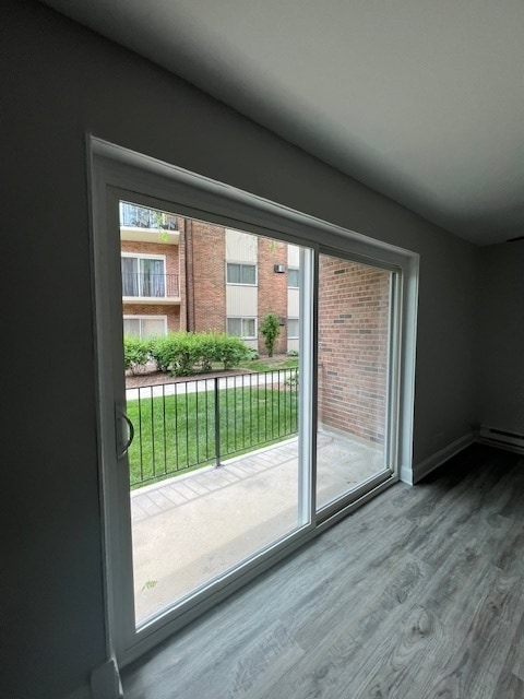 doorway to outside with a wealth of natural light and hardwood / wood-style floors