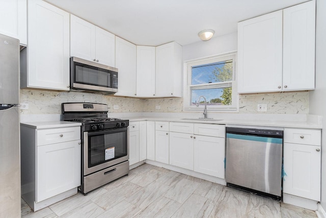 kitchen with white cabinets, appliances with stainless steel finishes, and sink