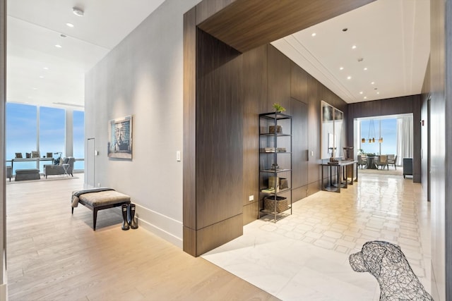 hallway with wood walls and expansive windows