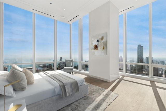 bedroom featuring multiple windows, wood-type flooring, and expansive windows