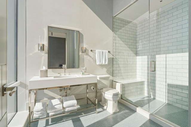 bathroom with tile patterned floors, toilet, sink, and walk in shower