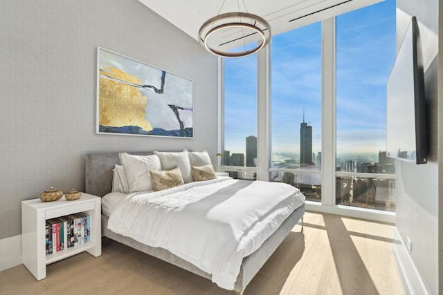 bedroom featuring multiple windows, expansive windows, and wood-type flooring