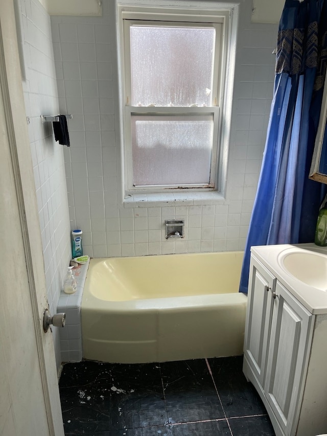 bathroom with tile flooring, tile walls, shower / tub combo, and vanity