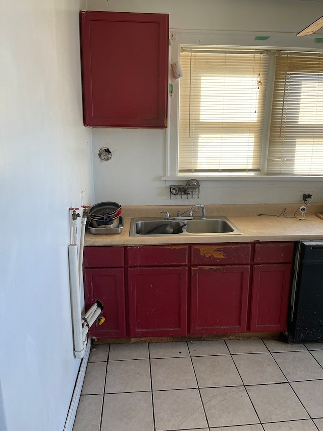 kitchen with black dishwasher, sink, and light tile flooring