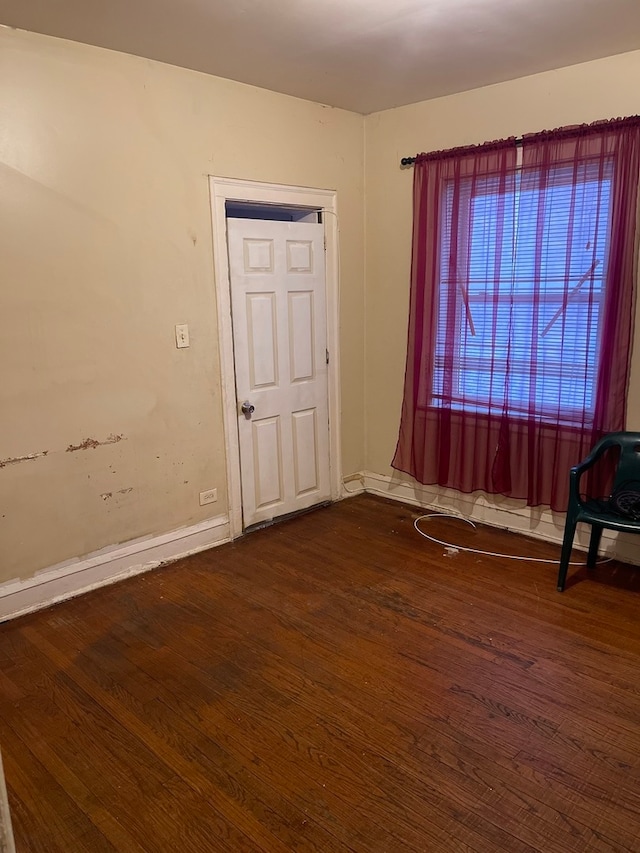 unfurnished room with dark hardwood / wood-style flooring