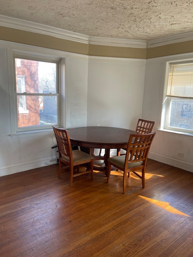 dining area featuring dark wood-type flooring, plenty of natural light, and a textured ceiling