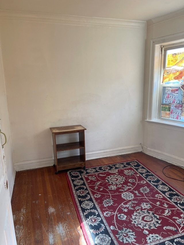 empty room featuring ornamental molding and dark hardwood / wood-style flooring