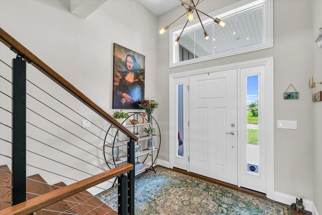 foyer with hardwood / wood-style floors, a notable chandelier, and a high ceiling