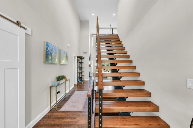 staircase featuring hardwood / wood-style floors and a barn door