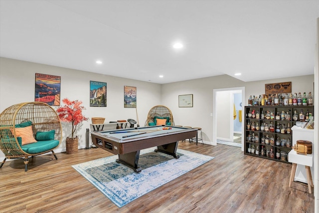 game room featuring billiards, bar, and light hardwood / wood-style flooring