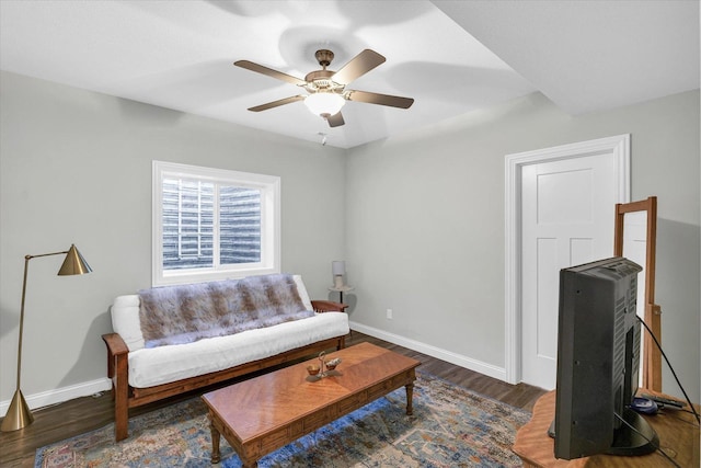 living room with dark wood-type flooring and ceiling fan