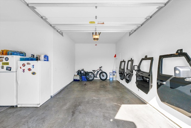 garage with a garage door opener and white fridge