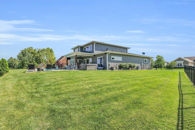 rear view of property with a patio and a lawn