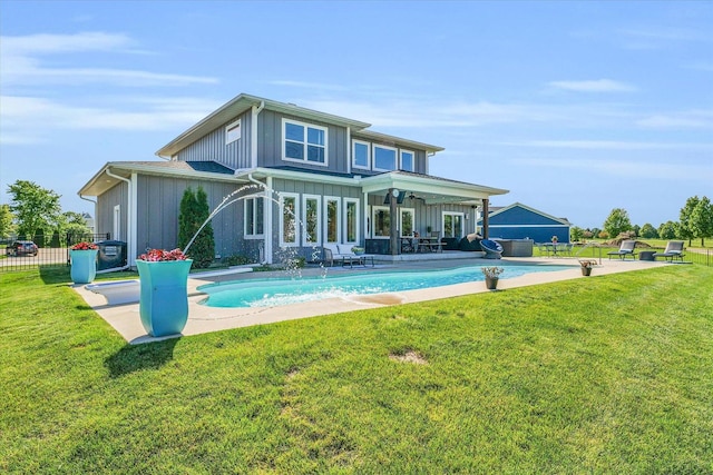 back of property with a yard, a patio, and pool water feature