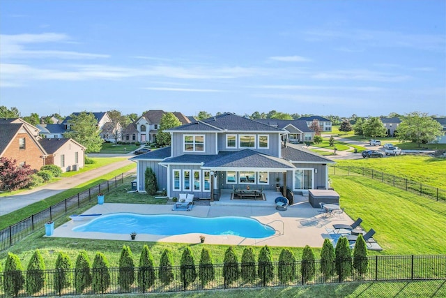 rear view of house featuring a fenced in pool, a lawn, outdoor lounge area, and a patio area