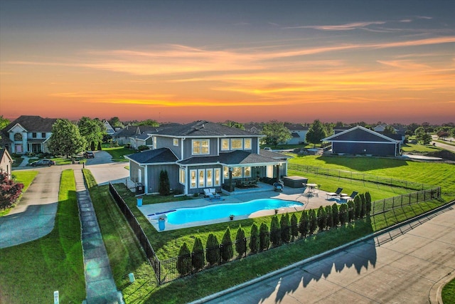 back house at dusk with an outdoor living space, a yard, a fenced in pool, and a patio area