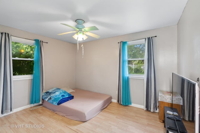 bedroom with light hardwood / wood-style flooring and ceiling fan