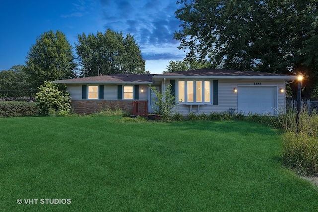 single story home with a garage and a lawn