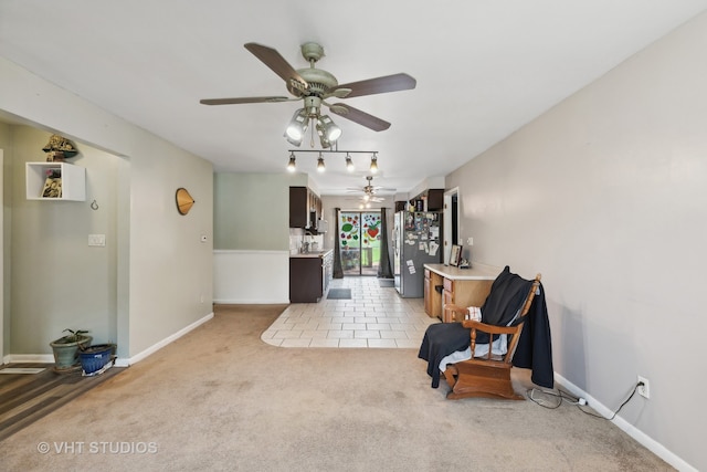 living area with ceiling fan and light colored carpet