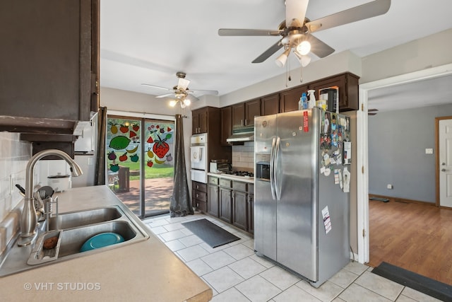 kitchen with sink, light hardwood / wood-style floors, tasteful backsplash, ceiling fan, and stainless steel fridge with ice dispenser