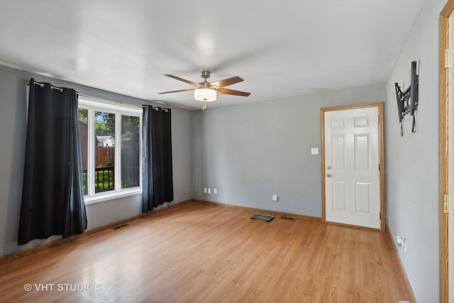 empty room with ceiling fan and light hardwood / wood-style flooring