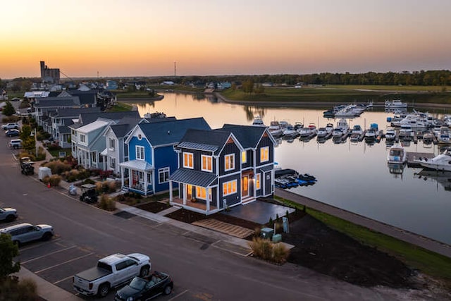 aerial view at dusk featuring a water view