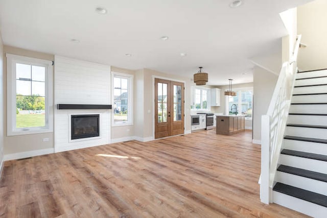 unfurnished living room featuring light hardwood / wood-style flooring and french doors