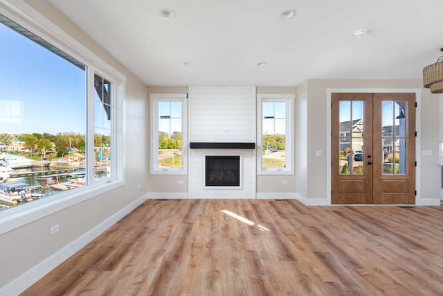 unfurnished living room featuring light hardwood / wood-style flooring and french doors