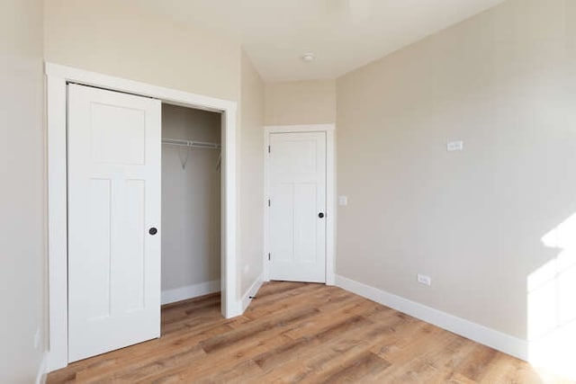 unfurnished bedroom featuring light hardwood / wood-style floors and a closet