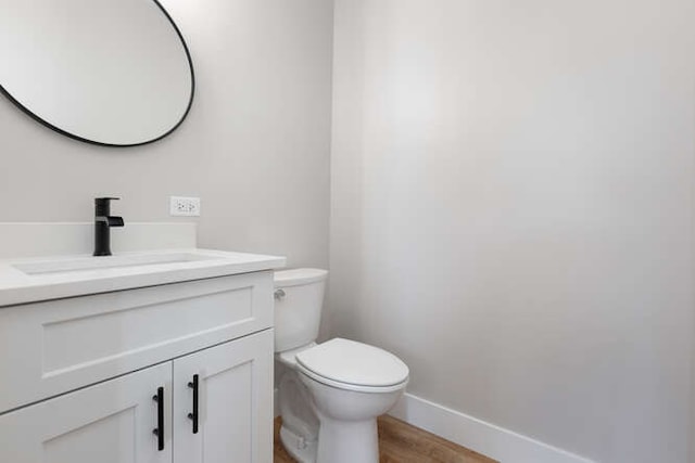 bathroom with vanity, hardwood / wood-style flooring, and toilet