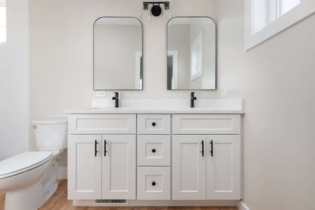 bathroom with vanity, toilet, and wood-type flooring