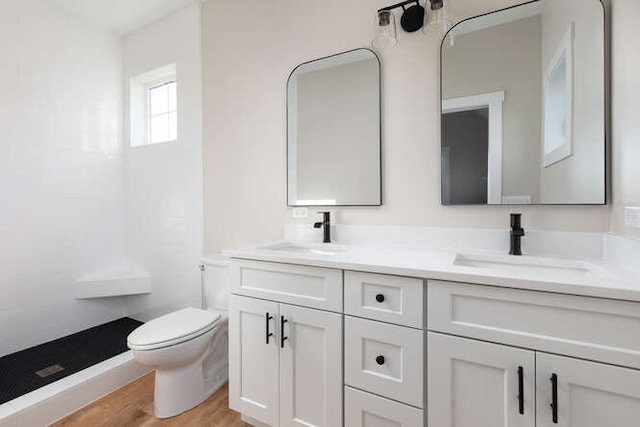 bathroom with vanity, hardwood / wood-style flooring, toilet, and walk in shower