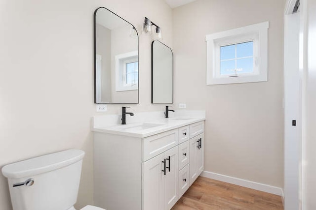 bathroom with wood-type flooring, vanity, and toilet