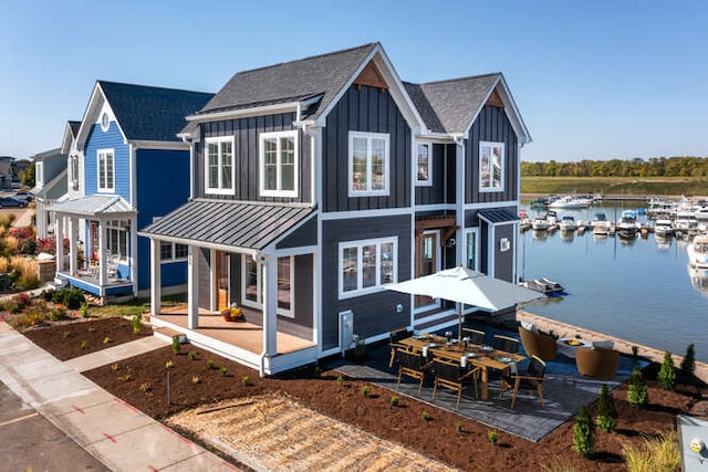 view of front facade with a patio area and a water view