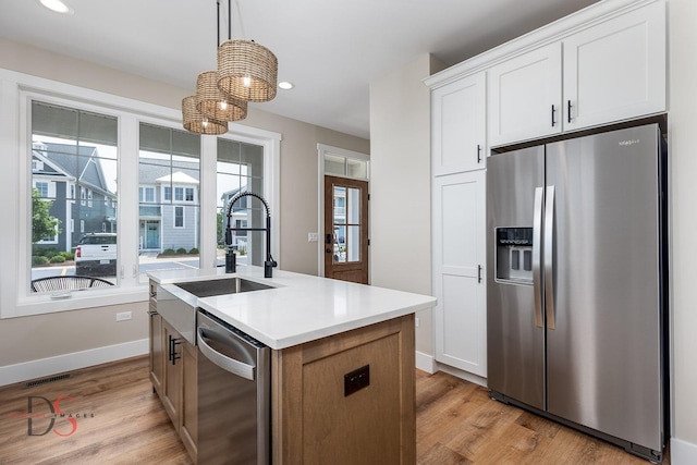 208 Leeward Way, Ottawa, IL 61350 - kitchen featuring appliances with stainless steel finishes, light wood-type flooring, a kitchen island with sink, recessed lighting, and decorative light fixtures